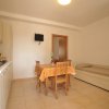Cucina con tavolo, sedie e divano letto.