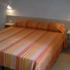 Letto matrimoniale con copriletto a righe arancioni.