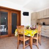 Cucina con tavolo apparecchiato e sedie in legno.