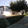 Giardino con vialetto e alberi vicino a una casa bianca.