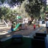 Bambini giocano in giardino con scivolo.