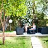 Due persone sedute in un giardino alberato.