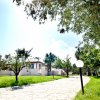 Viale lastricato verso una casa bianca in mezzo al verde.