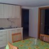 Cucina con tavolo coperto da tovaglia a girasoli e sedie di legno.
