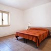 Camera da letto con letto matrimoniale e copriletto arancione.