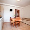 Cucina con tavolo, sedie e un divano letto.