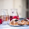 Croissant su un piatto con bevande in caraffe.
