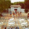 Persone che fanno esercizi all'aperto su una terrazza con sedie bianche.