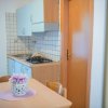 Cucina con tavolo, fornelli e fiori su un centrino.