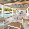 Lounge moderna con divani, vicino a una piscina azzurra.