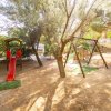 Area giochi all'aperto con scivolo e altalene.