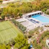 Campo da tennis e piscina vicino l'uno all'altra.