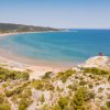 Spiaggia con mare azzurro e costa verde.