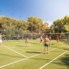 Persone giocano a pallavolo su un campo all'aperto.