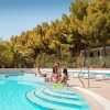 Persone rilassate a bordo piscina.