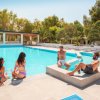Quattro persone rilassate a bordo piscina.
