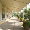 Portico coperto con piante in vaso e sedie lungo il lato.