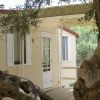 Una casa mobile chiara con una porta bianca, vista tra ulivi.