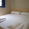 Un letto matrimoniale con due cuscini e asciugamani piegati.
