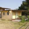 Piccola casa gialla con veranda immersa nel verde.