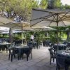 Ristorante all'aperto con tavoli apparecchiati.