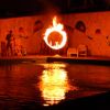 Cerchio infuocato di fronte a una piscina illuminata.