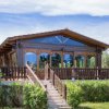 Casetta di legno con ampie finestre e giardino.