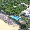 Vista aerea di un resort con spiaggia e piscina.