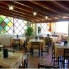 Sala ristorante con tavoli apparecchiati e parete con vetri colorati.