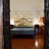 Letto con testiera in ferro battuto, pareti in pietra.