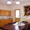 Sala da pranzo con tavolo in legno e dipinto su parete.