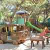 Un parco giochi in legno con scivolo verde.