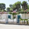 Una casa bianca con piante e fiori fucsia fuori.
