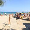 Spiaggia con ombrelloni colorati e passerella.