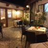 Un patio esterno con tavoli apparecchiati e sedie intorno.