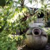 Anfore antiche in giardino lussureggiante.