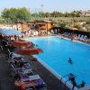Piscina con lettini e ombrelloni colorati.