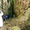 Persone camminano in una stretta gola rocciosa.