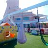 Parco giochi su prato sintetico con altalene.