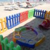 Recinto colorato in spiaggia con giochi per bambini.