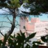 Vista sull'hotel rosa vicino al mare, tra gli alberi.
