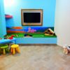 Una stanza colorata per bambini con giochi e sedie.