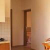Interno di cucina con fornelli, tavolo e sedie vicino a finestra.