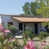 Una casa con tetto rosso circondata da cespugli fioriti.