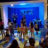 Un gruppo di bambini balla su un palco all'aperto.