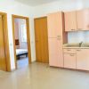 Cucina con mobili in legno e due porte a vista.